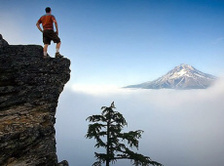 Man at ledge on mountain lookout